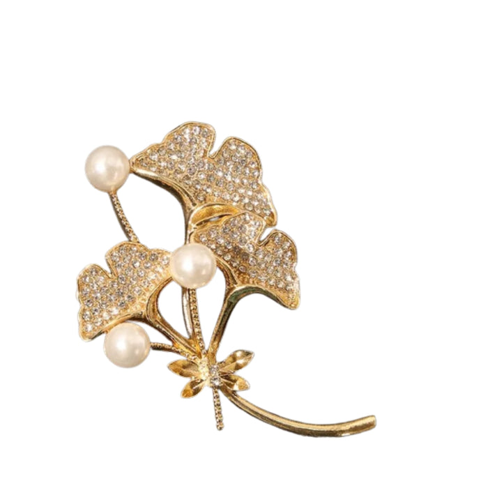 Gold brooch with leaves and pearls on a white background