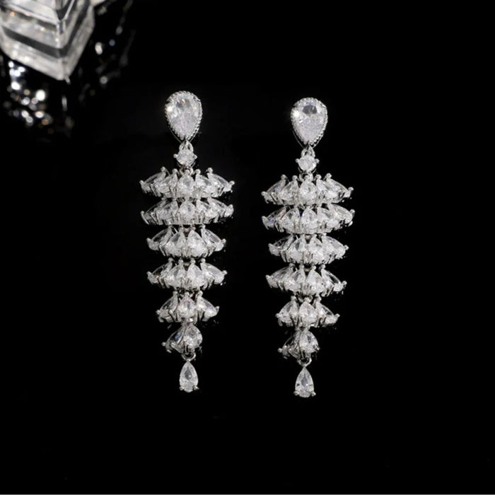 Pair of elegant, dangling earrings with teardrop-shaped gems and layered clear stones on a black background – 1600002193457 14066565