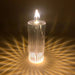 Decorative candle with a ribbed glass holder on a dark background