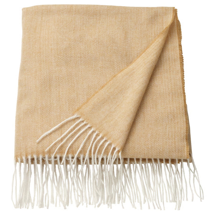 Beige blanket with white fringe on a white background