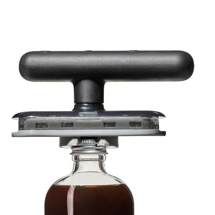 Black T-handle bottle opener shown removing cap from beverage bottle – ergonomic twist design for effortless opening – 1600004084340 13927404