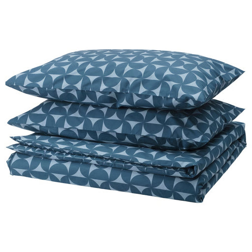 Neatly folded IKEA ÄNGSNEJLIKA duvet cover and two pillowcases in dark blue and light blue geometric pattern, showing circular motifs for a modern bedroom look.

