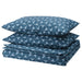 Neatly folded IKEA ÄNGSNEJLIKA duvet cover and two pillowcases in dark blue and light blue geometric pattern, showing circular motifs for a modern bedroom look.


