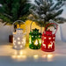 Three colorful lanterns with Christmas designs on a snowy background