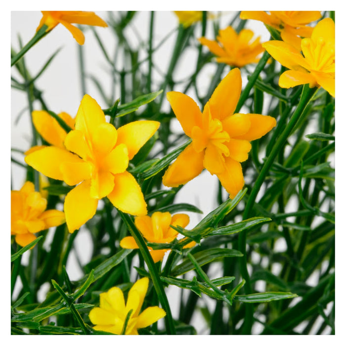 Close-up of the lifelike yellow flower petals and green budding stems of the IKEA FEJKA artificial plant.