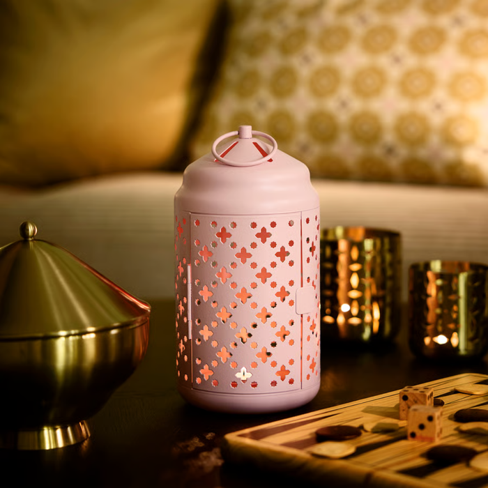 Pink cylindrical lantern with side latch and perforated body, showing hinged door for placing a tealight inside.