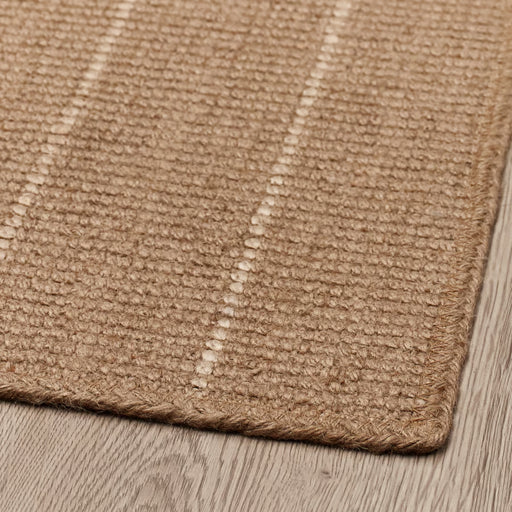 Close-up of a textured brown rug on a wooden floor