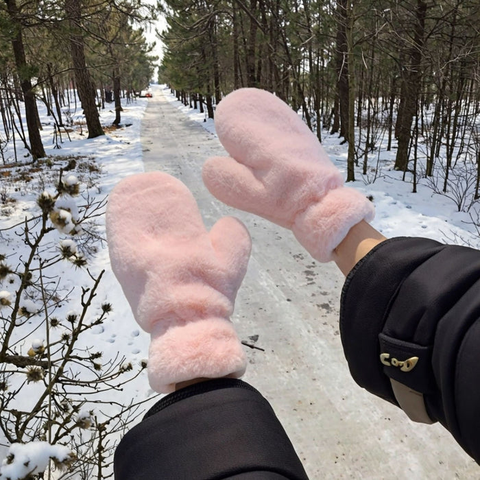 fluffy pink mittens worn outdoors in snowy forest path