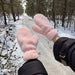fluffy pink mittens worn outdoors in snowy forest path