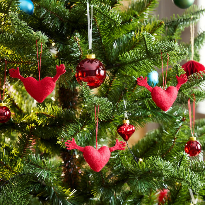 VINTERFINT heart ornaments hanging on a decorated Christmas tree alongside red and blue baubles, adding festive charm