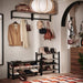 Entryway with coat rack, shoes, and handbags on a wall.