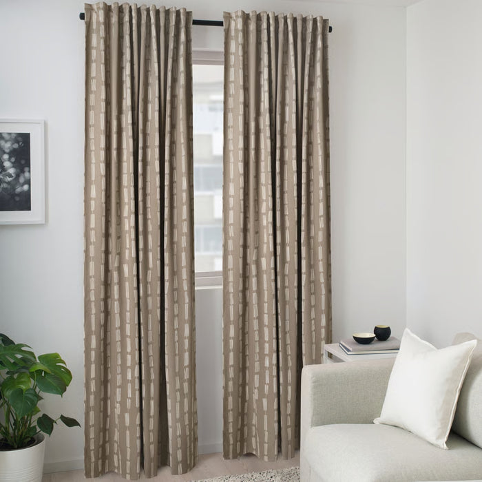 Curtains styled in modern living room with gray sofa, side table, potted plant, and framed wall art, highlighting neutral beige tone