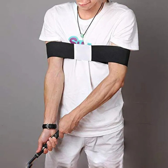Person wearing a black arm brace on one arm, holding a golf club against a gray background