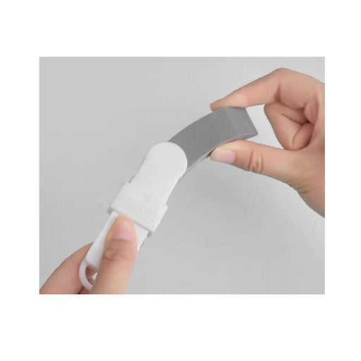 Hand holding a gray and white cable against a light gray background