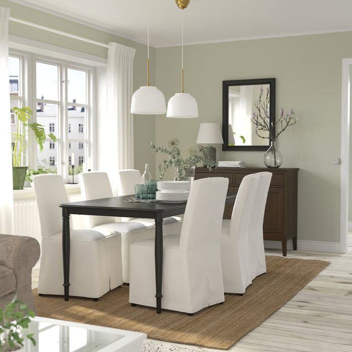 Dining room with a table and chairs in a well-lit room.