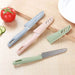 Three colorful kitchen knives on a wooden surface with vegetables.