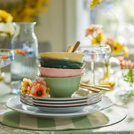 IKEA UPPLAGA bowls stacked on striped tablecloth with gold utensils and floral decor in bright spring-themed setup