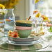 IKEA UPPLAGA bowls stacked on striped tablecloth with gold utensils and floral decor in bright spring-themed setup