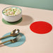 red silicone round mat used as trivet for hot pot