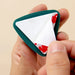 Hand holding a triangular card holder with playing cards inside against a beige background