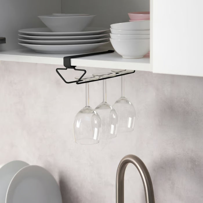 Clip-on rack installed under a white kitchen cabinet, holding three stemmed wine glasses neatly.