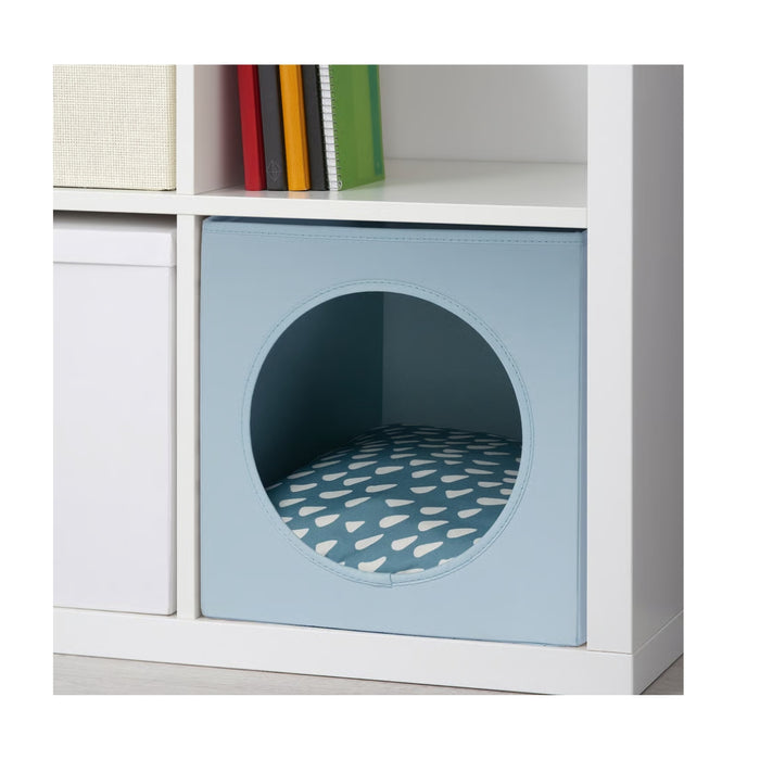Grey-blue UTSÅDD cat house with circular opening and patterned cushion, placed inside white shelving unit. Fits perfectly in KALLAX shelf – 50572105.