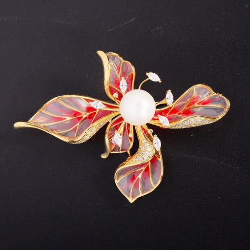 Elegant flower-shaped brooch featuring four glossy petals in a gradient blend of red and translucent enamel, each trimmed with gold and adorned with small white leaf-shaped stones. At the center sits a luminous round pearl, adding a touch of vintage luxury. The piece is set against a deep black backdrop, enhancing its vibrant tones and intricate craftsmanship—ideal for pairing with ethnic wear, evening gowns, or gift boxes -1600003190322 13048867.