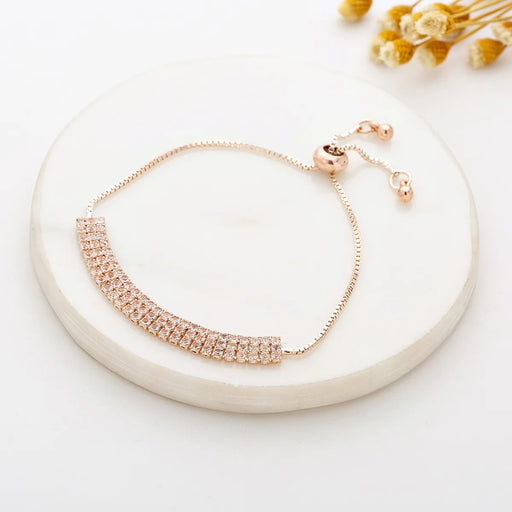 Rose gold bracelet on a white plate with dried flowers