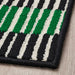 Close-up of an IKEA VÄNDPLATS Door Mat with green, black, and white geometric pattern on a wooden floor.