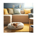 Small dog sleeping in UTSÅDD pet bed, light grey, M – plush round design on yellow rug in cozy living room with beige sofa, colorful cushions, and blue wall – 70570582.