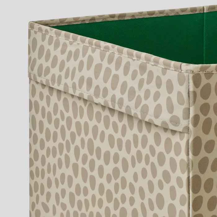 Storage bin with beige patterned exterior and green interior on a light gray background