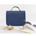 Travel storage waterproof bag, blue. Soft fabric case with top handle and logo tag, placed beside dried plants, book, and cream tube – minimalist styling for travel setup – 13403615.