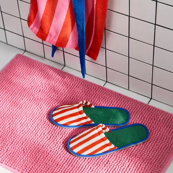 IKEA SKOGSSALLAT Slippers, red/white striped, L/XL, placed on a pink textured bath mat. The bold-striped design features a soft green insole and blue trim.-90596053