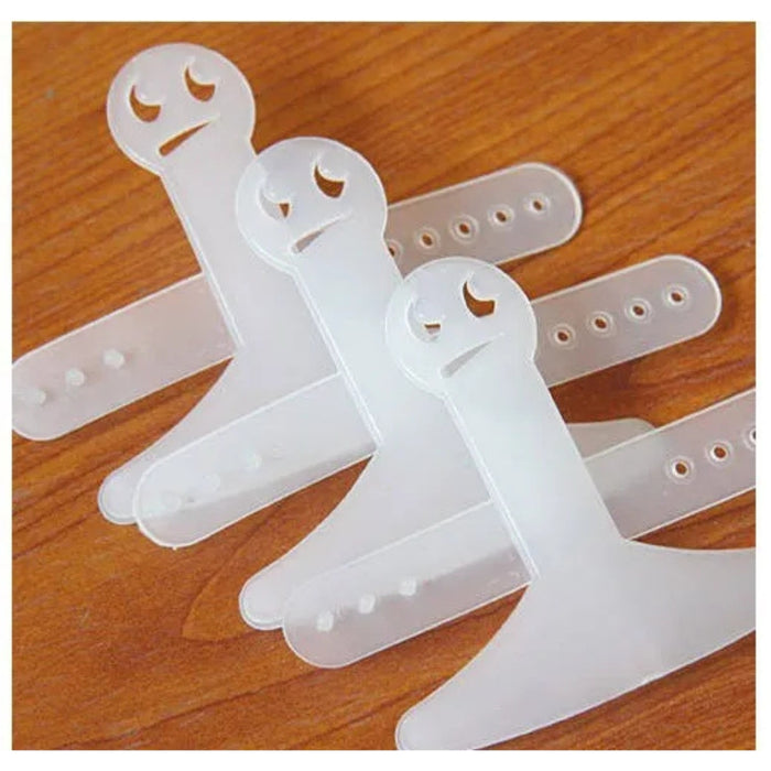 Clear plastic straps with cut-out designs on a wooden surface