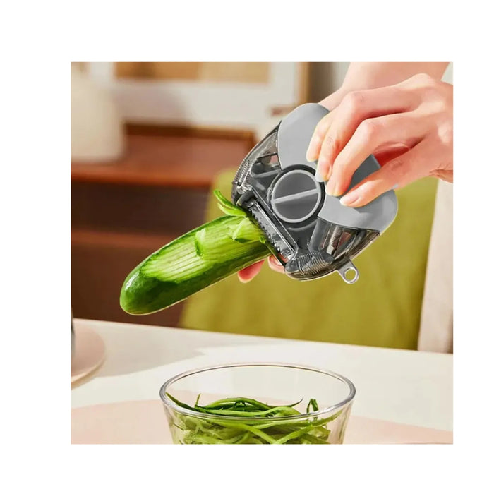Person using a vegetable peeler to slice a cucumber over a glass bowl on a kitchen counter.
