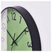 Wall clock with green face and black frame on a white background