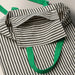 Close-up of MÄVINN bag’s inner pocket and horizontal stripe pattern, showcasing textile craftsmanship and contrast stitching