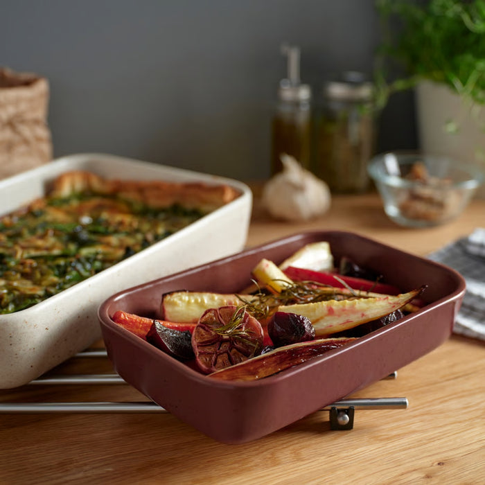 IKEA LYCKAD Oven/serving dish set of 2, light beige/red-brown, filled with roasted vegetables and casserole on wooden kitchen counter - 90607952
