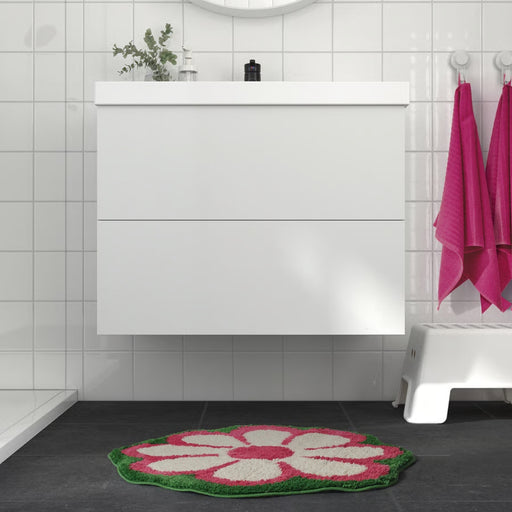 KEA KÄRRKNIPPROT Bathmat, floral pattern, multicolour bright pink, 65 cm, placed in a modern bathroom with a white vanity and a round mirror.-90596053