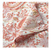 Floral patterned fabric with red and pink colors on a white background