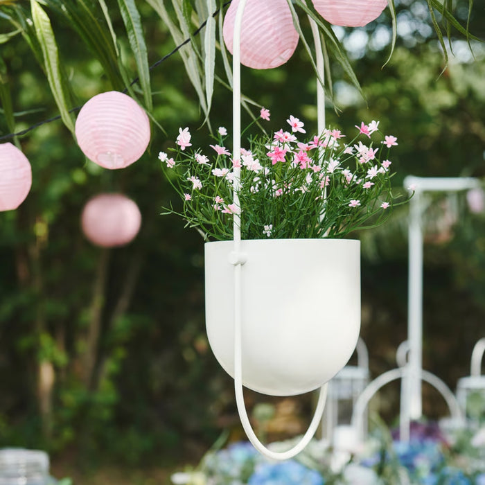 IKEA FEJKA artificial baby’s breath pink flowers in white hanging planter, outdoor garden setting with lanterns"
