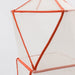 Geometric mesh chair with orange frame on a light gray background