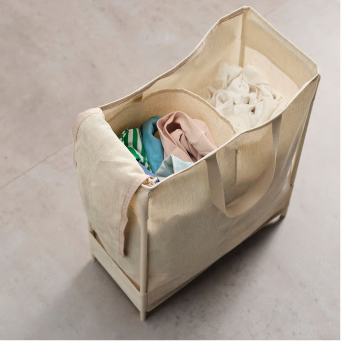 Beige laundry basket with clothes on a light gray background