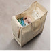 Beige laundry basket with clothes on a light gray background