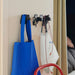 IKEA FRÖSÅDD black hooks holding tote bag, keys, and drawstring pouch in a cozy room