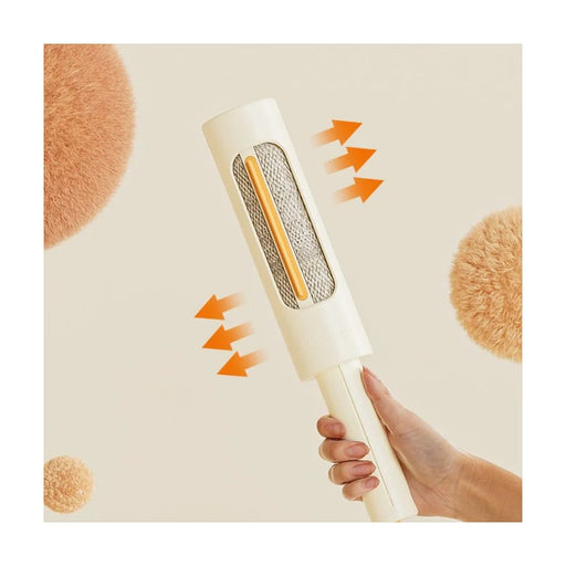 Hand holding a lint remover with arrows indicating movement on a beige background