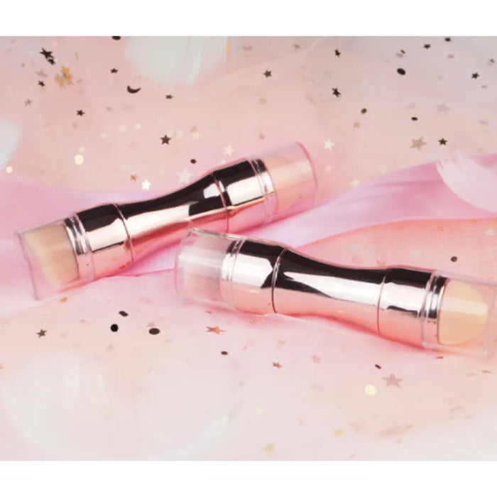 Two rose gold makeup brushes on a pink and white background with star patterns