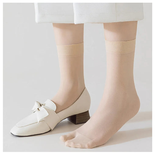 Beige socks worn with white shoes on a light gray background