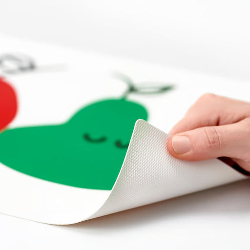 Hand holding a piece of paper with a green character on a white background