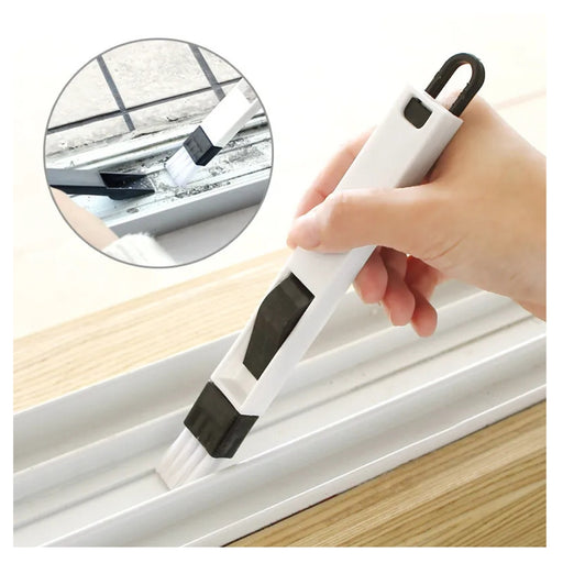 Hand using a white window cleaning tool with black accents to clean a window.